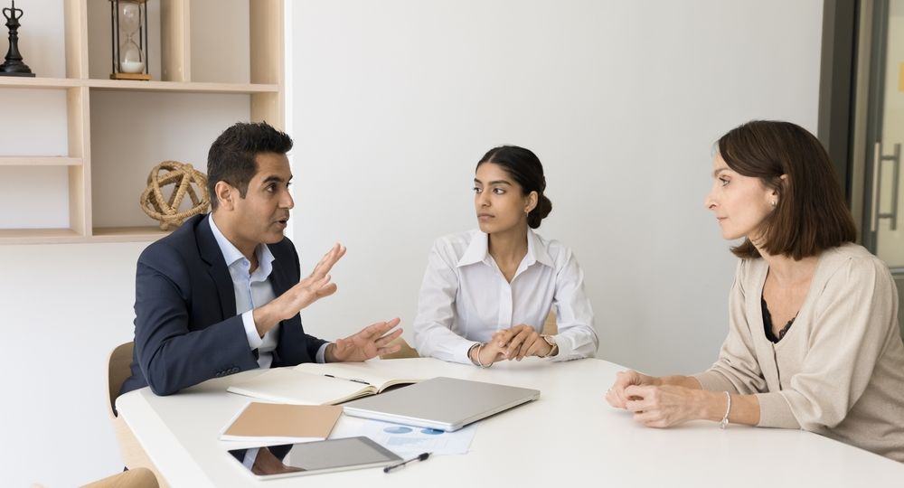 Engaged,Serious,Indian,Business,Leader,Man,Talking,To,Diverse,Colleagues